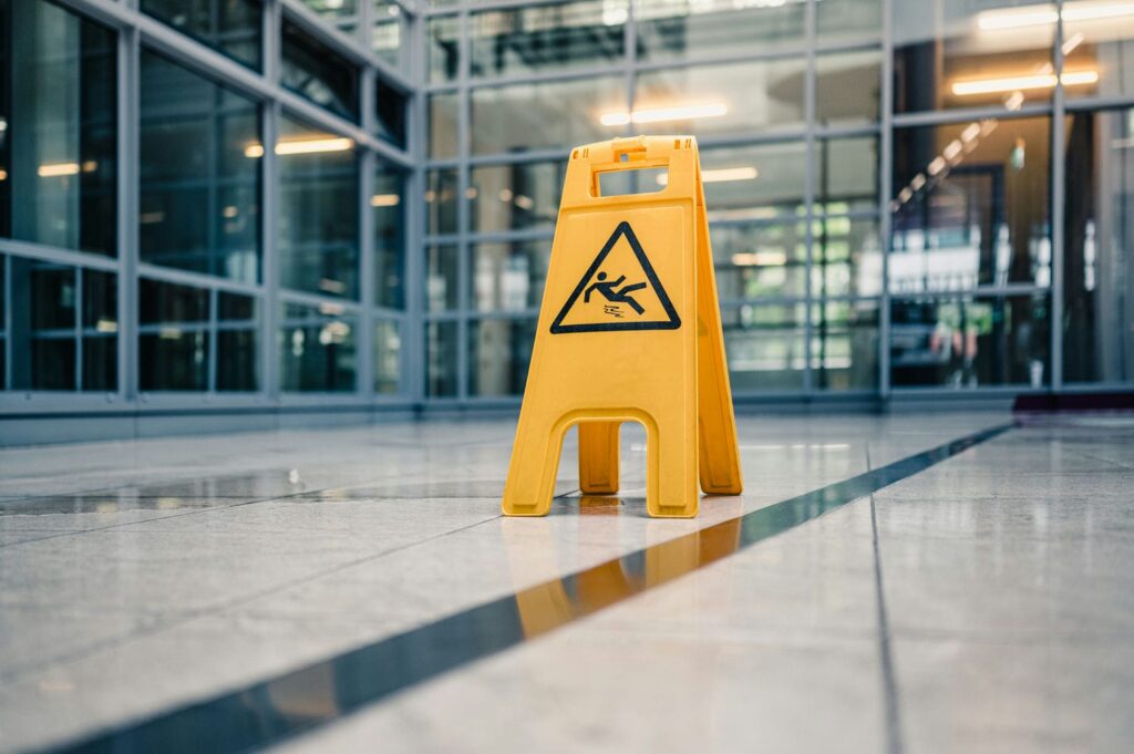 Wet floor caution sign on a glossy lobby floor, a common condo lobby hazard affecting liability